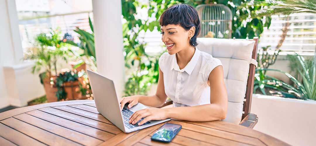 P2-Fiber-Mobile-6-1-25 Woman sitting on floor waving at laptop with dog